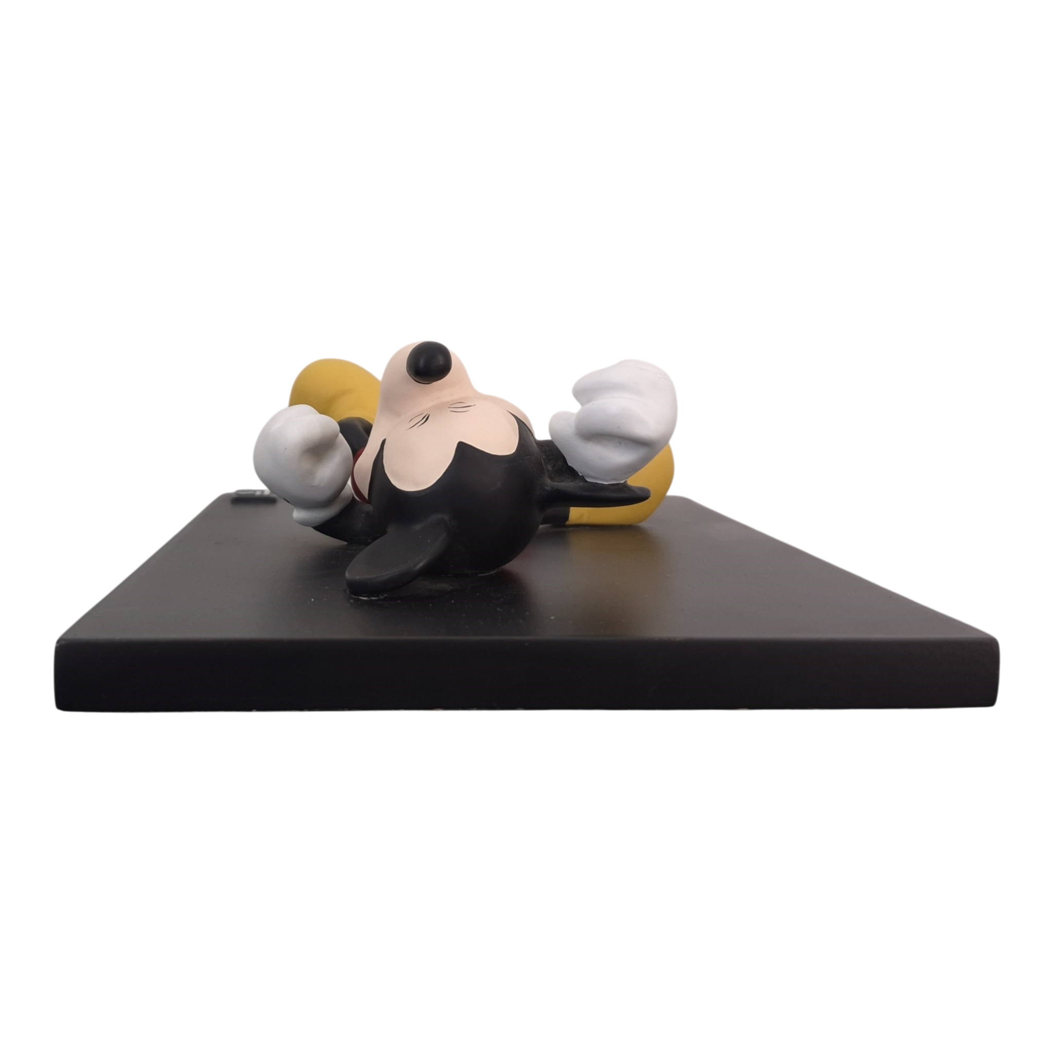 Partially visible Mickey Mouse statue lying on a dark display pedestal.